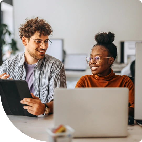 Two coworkers tuning into the Duo Live Demo webinar in an office.
