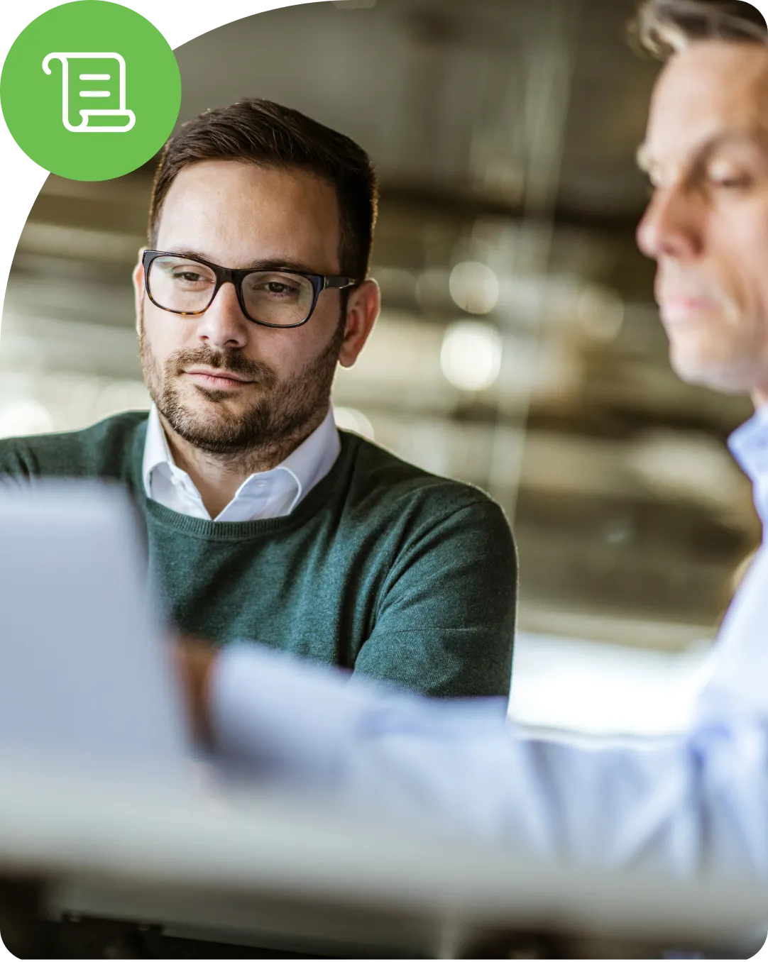 Two colleagues looking at Duo security on a laptop to review how to protect their business security stack to meet compliance requirements for their business.