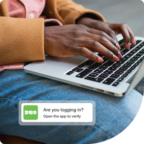 Trusted user working on a laptop using Duo multi-factor authentication with a simple prompt to gain secure access