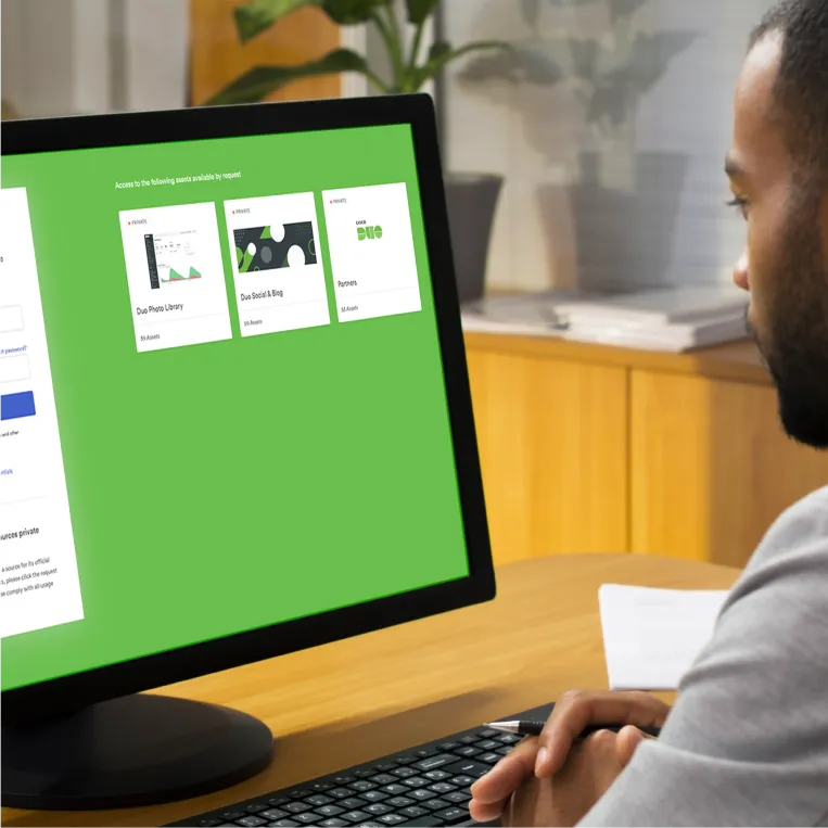 Person at desk viewing a screen with Duo photo library, Duo social & blog, and partner sections.