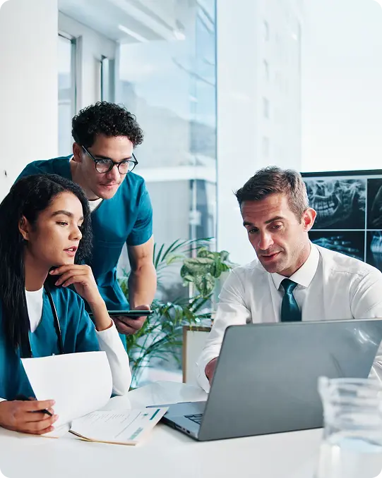 Medical team reviews patient dental X-rays on a laptop, underscoring the role of cybersecurity in keeping patient data secure.